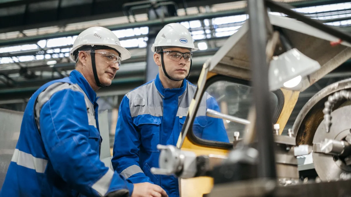 Due lavoratori con casco di protezione in reparto